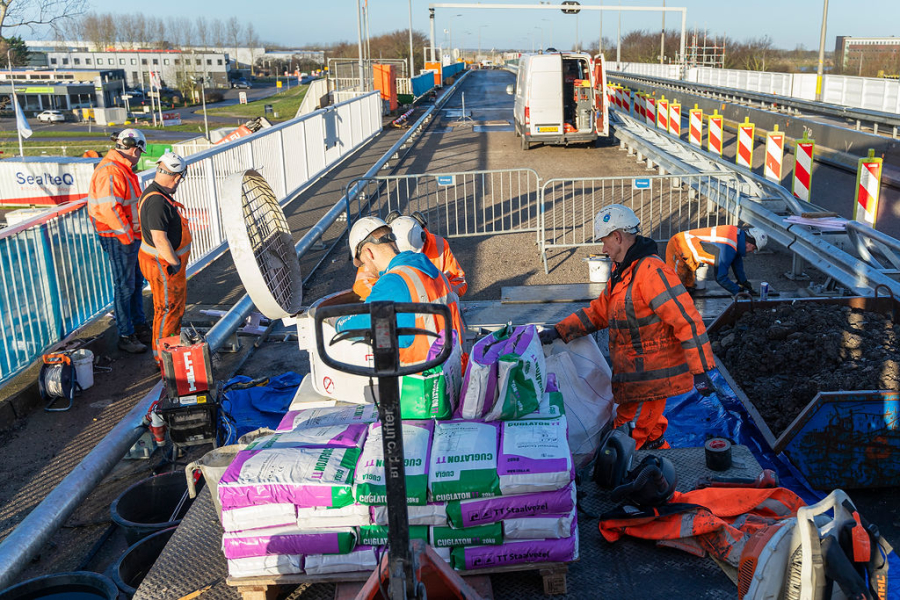 Mannen aan het werk op Kooybrug met zakken